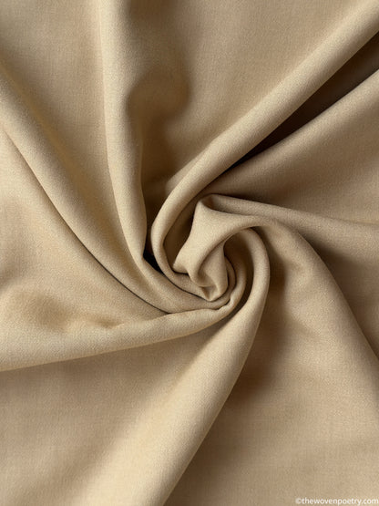 Close-up of beige fabric with a swirl pattern by Woven Poetry