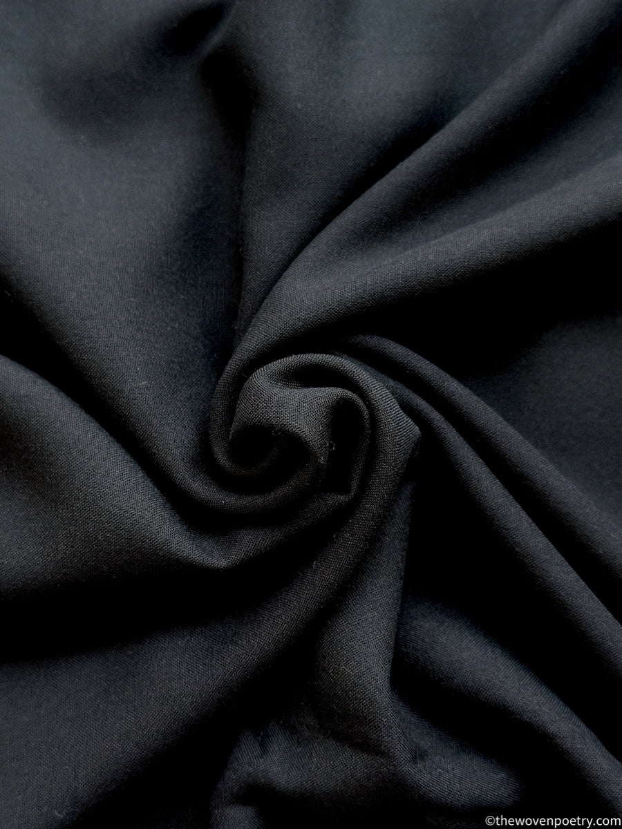Close-up of Black fabric with a swirl pattern by Woven Poetry
