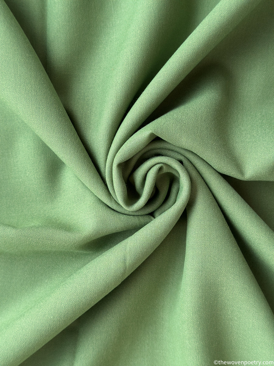 Close-up of green fabric by woven Poetry with folds