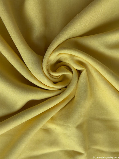 Close-up of yellow fabric with a swirl pattern by Woven Poetry