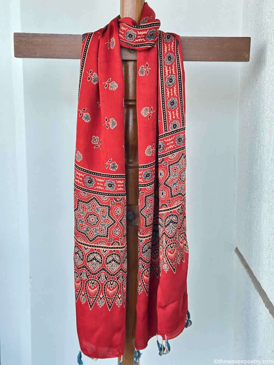 Full view of red handcrafted stole with floral Ajrakh inspired motifs and decorative border patterns