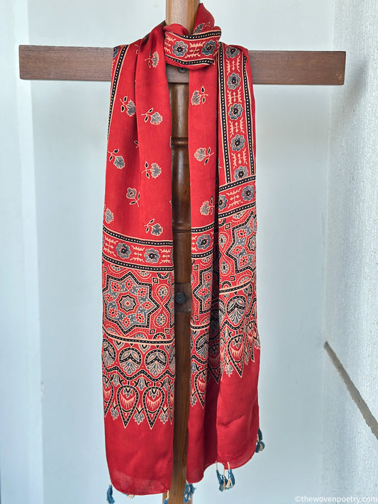 Full view of red handcrafted stole with floral Ajrakh inspired motifs and decorative border patterns