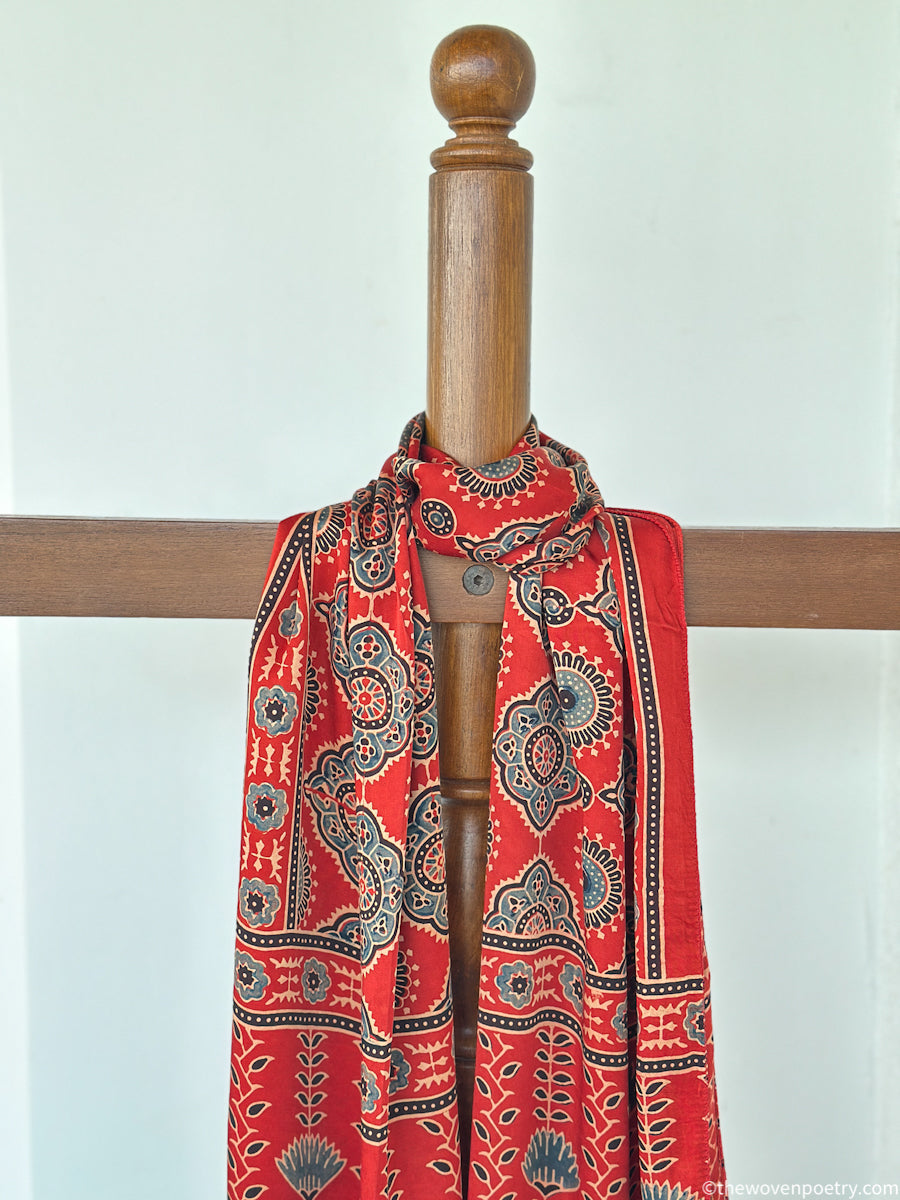 Handcrafted red Ajrakh floral stole with blue and ivory border detailing by Woven Poetry