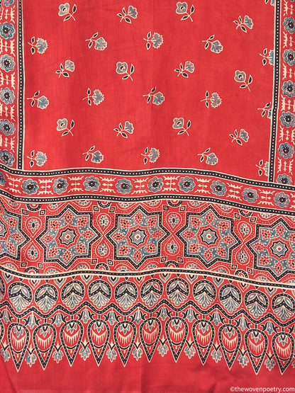 Close-up of handcrafted red stole featuring Ajrakh inspired floral motifs and intricate border design